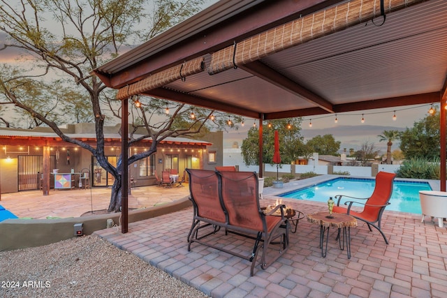 patio terrace at dusk with a fenced in pool