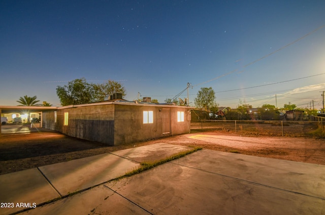 property exterior at dusk with a patio area