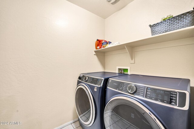 clothes washing area featuring light tile patterned flooring and separate washer and dryer