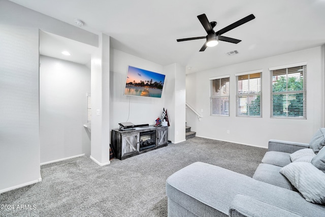 carpeted living room with ceiling fan