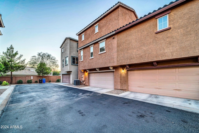 exterior space with central AC and a garage