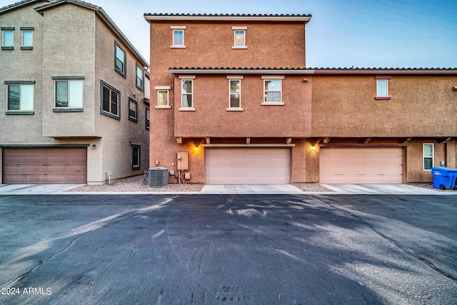 view of front of home with central AC unit and a garage