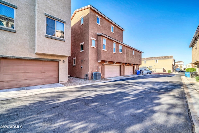 view of home's exterior with a garage and cooling unit