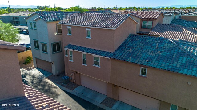 exterior space with central air condition unit and a garage