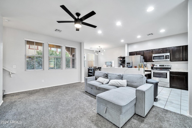 carpeted living room featuring ceiling fan with notable chandelier