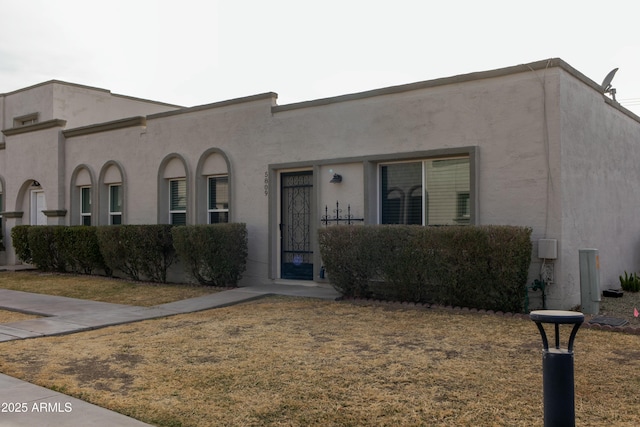 view of front of house with a front yard and stucco siding