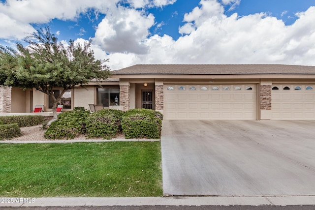 view of front of home featuring concrete driveway, a front lawn, an attached garage, and stucco siding