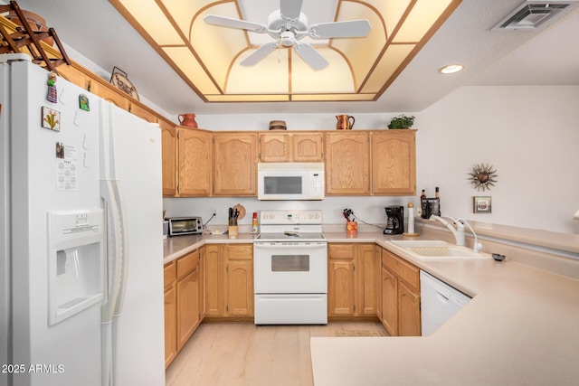 kitchen with a peninsula, white appliances, a sink, visible vents, and light countertops