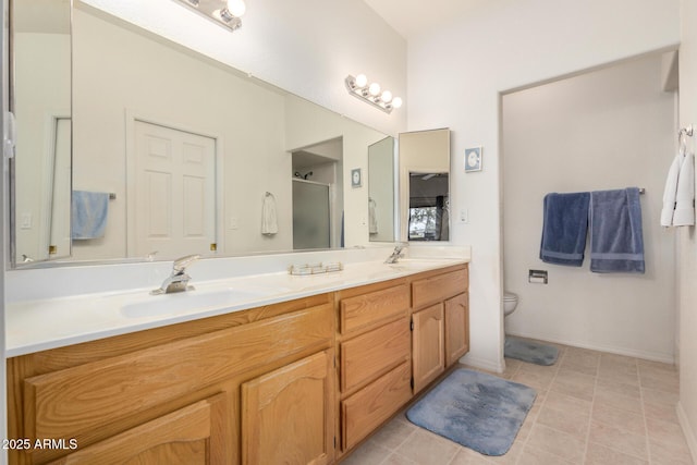 full bathroom with double vanity, a stall shower, a sink, and tile patterned floors