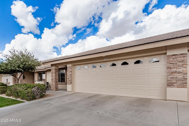 view of front of house with a garage, stone siding, driveway, and stucco siding