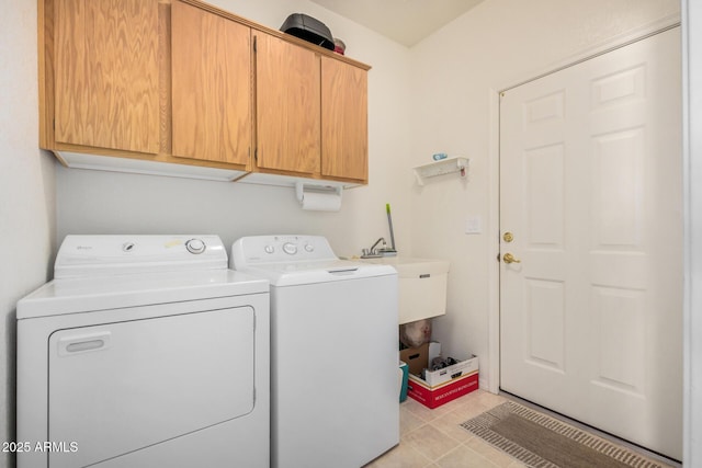 laundry room with cabinet space, light tile patterned floors, and washing machine and clothes dryer