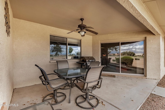 view of patio featuring a grill, outdoor dining area, and a ceiling fan