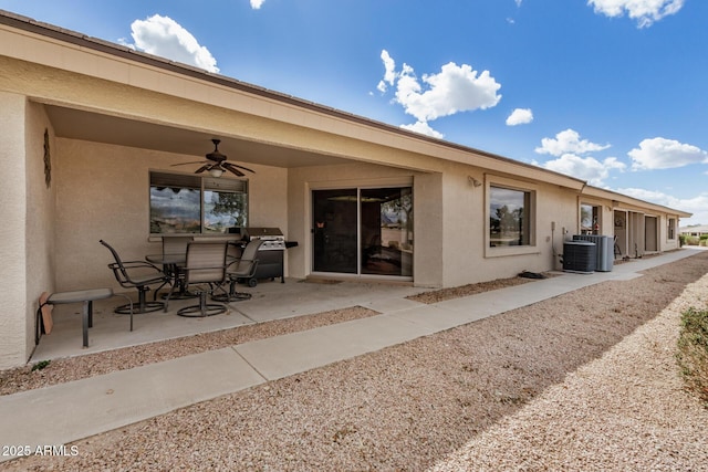 rear view of property with stucco siding, central AC unit, a ceiling fan, and a patio