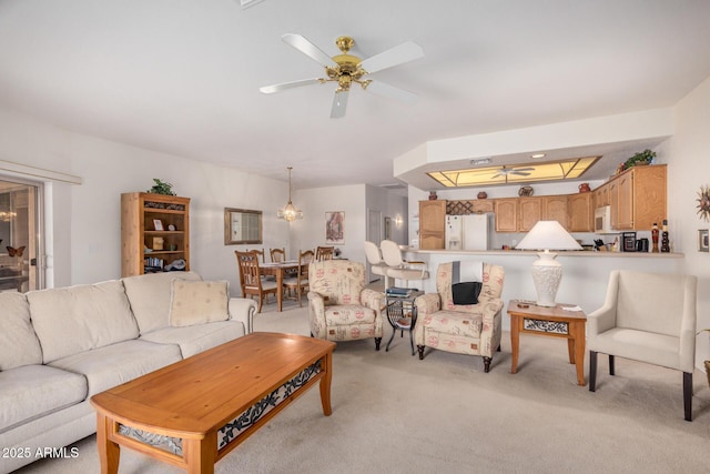 living area with light colored carpet and ceiling fan with notable chandelier