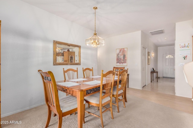 dining space featuring a chandelier and visible vents