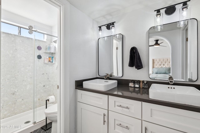 bathroom featuring vanity, toilet, and a shower with shower door