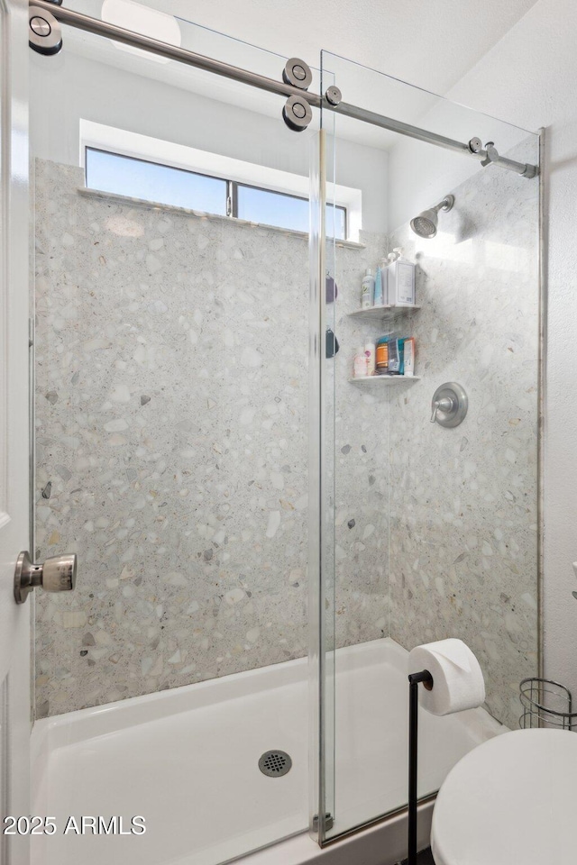 bathroom with toilet and an enclosed shower