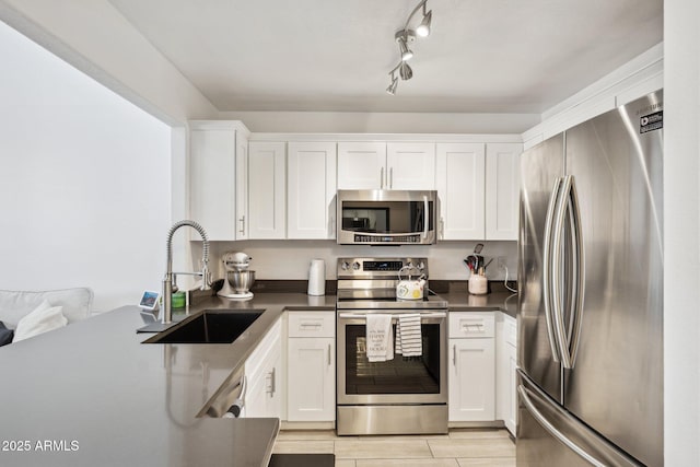 kitchen featuring stainless steel appliances, white cabinetry, and sink