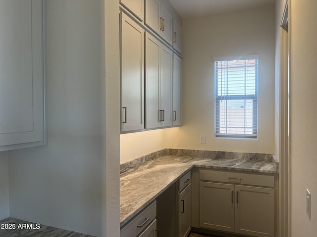 kitchen with gray cabinetry and light stone countertops