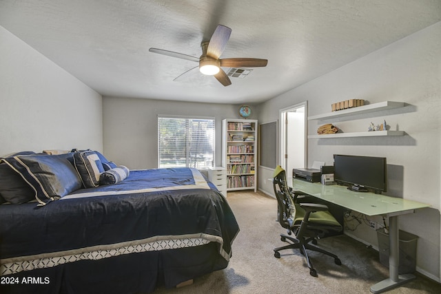 carpeted bedroom featuring ceiling fan and a textured ceiling