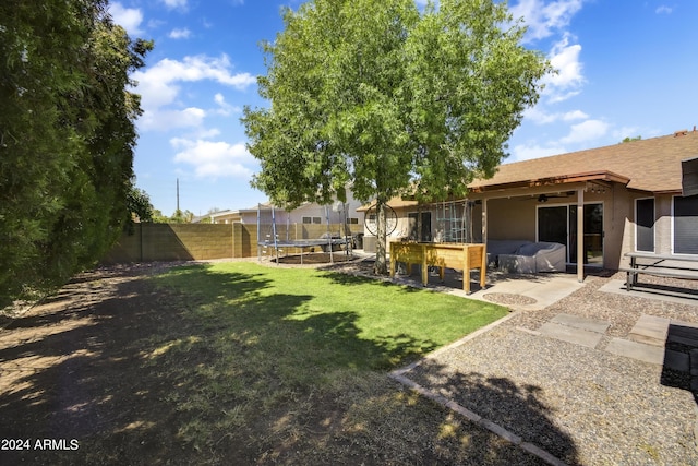 view of yard with ceiling fan, a patio area, and a trampoline