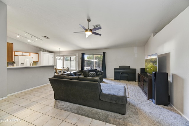 living room featuring ceiling fan with notable chandelier, light colored carpet, and vaulted ceiling