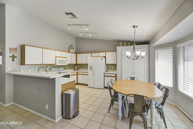 kitchen featuring white appliances, kitchen peninsula, tasteful backsplash, decorative light fixtures, and white cabinetry