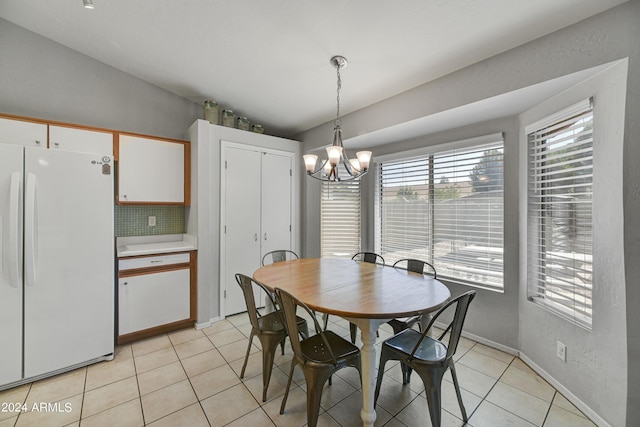 tiled dining area with a chandelier and vaulted ceiling