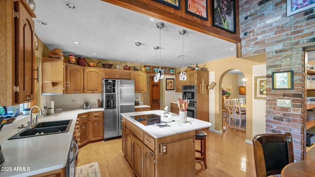 426 E Carol Ann Way, Phoenix, AZ 85022 - kitchen featuring appliances with stainless steel finishes, arched walkways, light countertops, light wood-style floors, and a center island