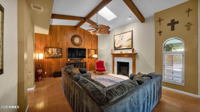 426 E Carol Ann Way, Phoenix, AZ 85022 - living area with beamed ceiling, wooden walls, a fireplace, wood finished floors, and a skylight