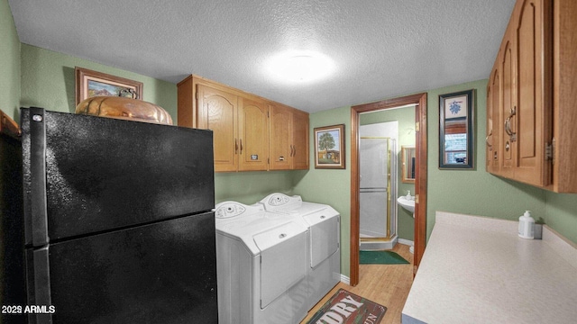 426 E Carol Ann Way, Phoenix, AZ 85022 - laundry room with separate washer and dryer, light wood finished floors, cabinet space, and a textured ceiling