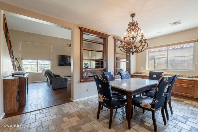 7169 S Dodane Ct, Gilbert, AZ 85298 - dining area featuring a chandelier, stone tile flooring, and baseboards