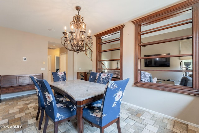 7169 S Dodane Ct, Gilbert, AZ 85298 - dining room featuring stone tile floors, a chandelier, and baseboards