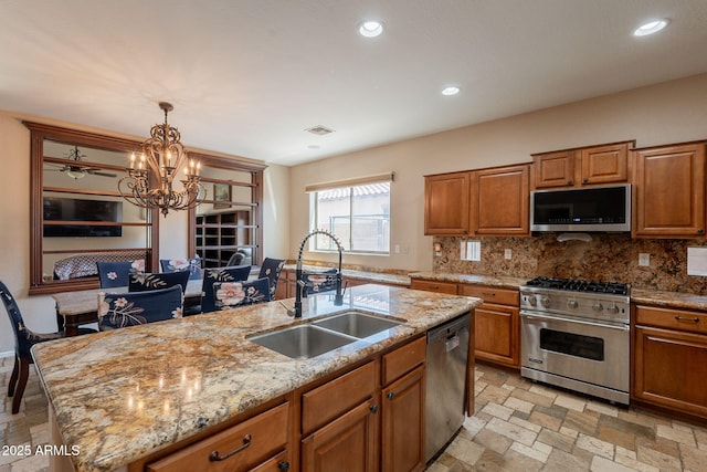 7169 S Dodane Ct, Gilbert, AZ 85298 - kitchen with appliances with stainless steel finishes, a sink, decorative backsplash, brown cabinets, and recessed lighting