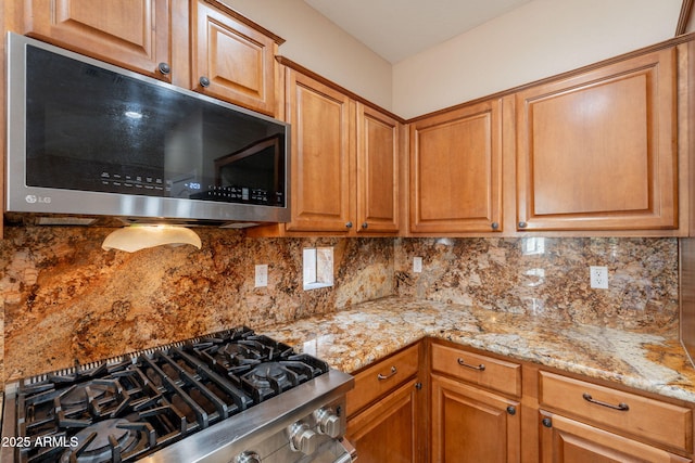 7169 S Dodane Ct, Gilbert, AZ 85298 - kitchen with appliances with stainless steel finishes, tasteful backsplash, and light stone countertops