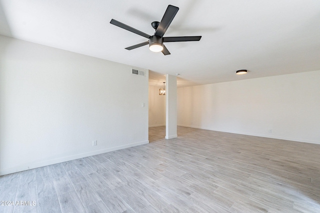 spare room featuring light hardwood / wood-style flooring and ceiling fan with notable chandelier