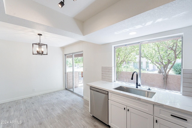 kitchen featuring pendant lighting, white cabinetry, dishwasher, light stone counters, and sink