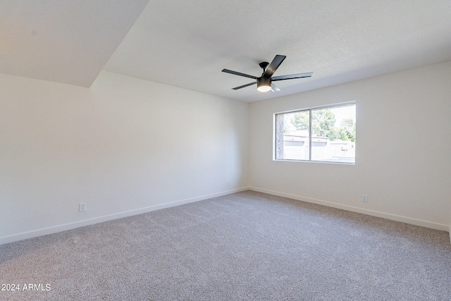 spare room with ceiling fan and carpet