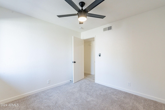 empty room featuring ceiling fan and light carpet