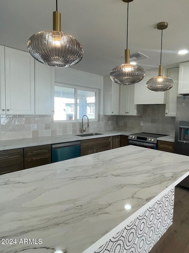 kitchen with appliances with stainless steel finishes, backsplash, dark wood-type flooring, sink, and white cabinetry