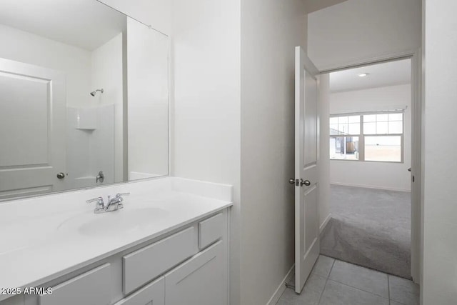 full bath featuring tile patterned flooring, walk in shower, vanity, and baseboards
