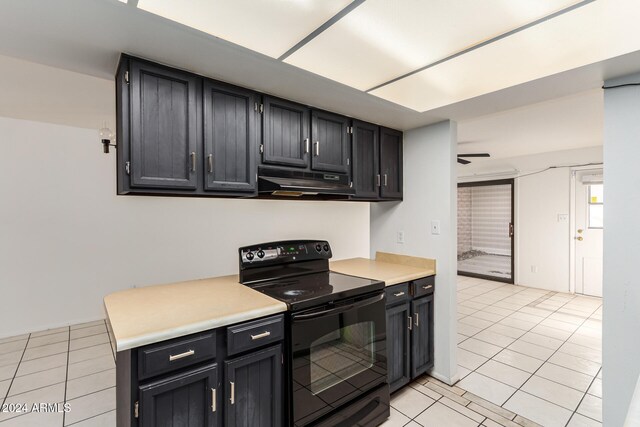 kitchen featuring electric range, light tile patterned floors, and exhaust hood