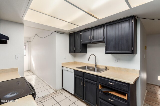 kitchen with dishwasher, stove, light tile patterned floors, and sink