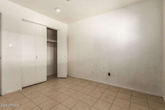 unfurnished bedroom featuring a closet and light tile patterned floors