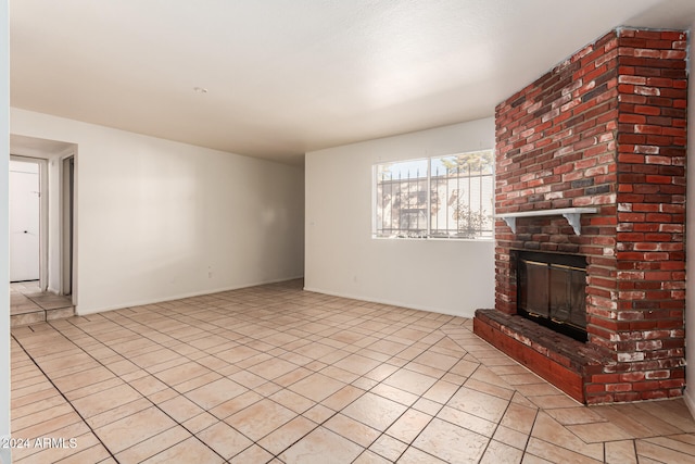 unfurnished living room featuring a fireplace and light tile patterned floors