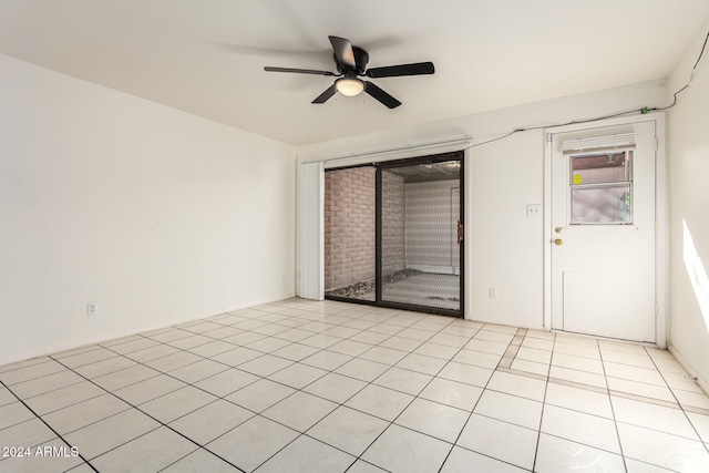 tiled spare room with ceiling fan