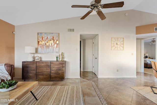 interior space with ceiling fan, vaulted ceiling, and light tile patterned flooring