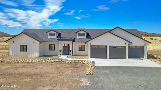 modern farmhouse featuring driveway, a shingled roof, a garage, and board and batten siding