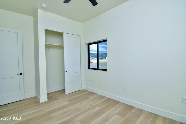 unfurnished bedroom featuring a closet, baseboards, ceiling fan, and light wood-type flooring