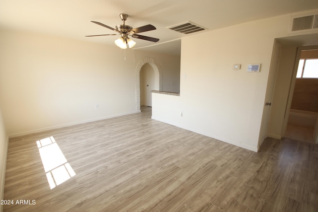 spare room with ceiling fan and light wood-type flooring